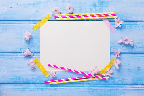 Preview: Bright Pink And Yellow Paper Straws, Tender Flowers And Empty Tag For Text On Blue Wooden
