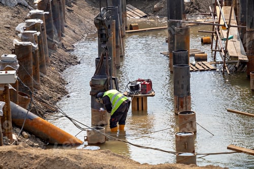 Preview: Welder Wearing Protective Clothing And Welding Industrial Construction For Erosion Control. River