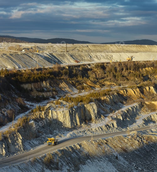 Preview: Stone Quarry In Evening Sunlight With Operating Heavy Mining Equipment. Mining Industry.