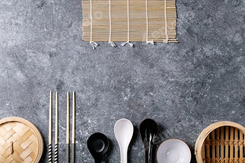 Preview: Traditional Asian Kitchen Utensils Chopsticks, Ceramic Spoons, Bowls And Bamboo Steamer Over Blue