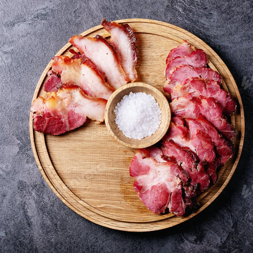 Preview: Cooked Pork Meat On Wooden Round Board Served With Tomatoes, Salt, Pepper And Olive Oil Over Dark