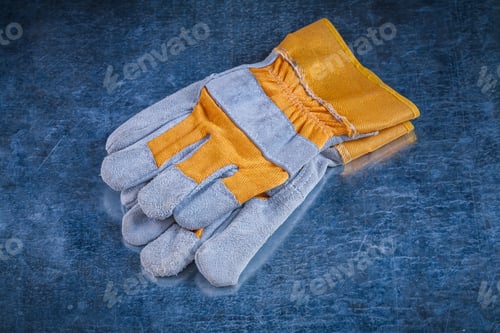 Preview: Pair Of Safety Working Gloves On Scratched Vintage Metallic Background Close Up Image Construction