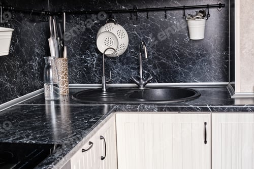 Preview: The Kitchen Is Made Of White Wood With A Black Countertop And An Apron. Knives, Spoons, A Colander