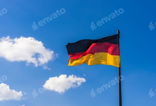 Preview: German Flag Waving In The Wind With Blue Cloudy Sky On A Sunny Day.