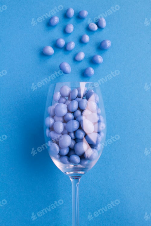 Preview: Blue Candy In A Wine Glass In The Center Of The Blue Background.Top View.Copy Space. Location