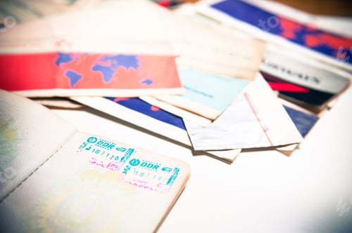 Preview: Old Passport With East Germany Stamp And Airlines Tickets Out Of Focus In Background