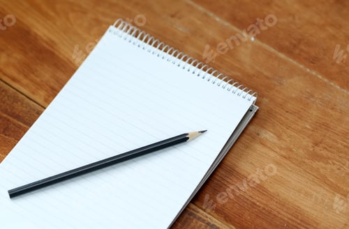 Preview: Black Pencil Lying On The Notepad On A Wooden Table.