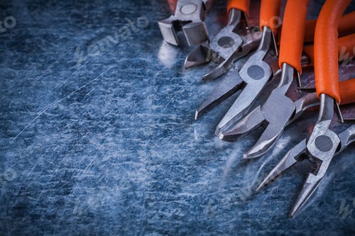 Preview: Insulated Electric Metal Nippers Gripping Tongs On Scratched Metallic Surface.