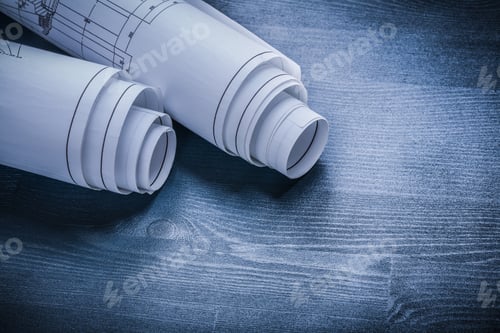 Preview: Rolled White Blueprints On Wood Board.