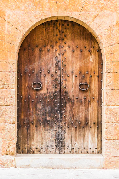 Preview: Rustic Old Brown Wood Door With Sandstone Doorway Arch, Detail Closeup.