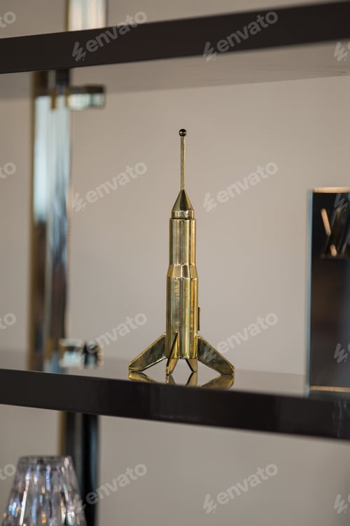 Preview: Decor Souvenir In The Form Of A Rocket, A Gift Figurine For A Man, A Gold Rocket On A Shelf.