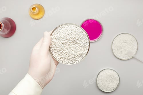 Preview: Top View Of A Laboratory Assistant Holding A Bowl With White Chemical Granules In His Hand With A