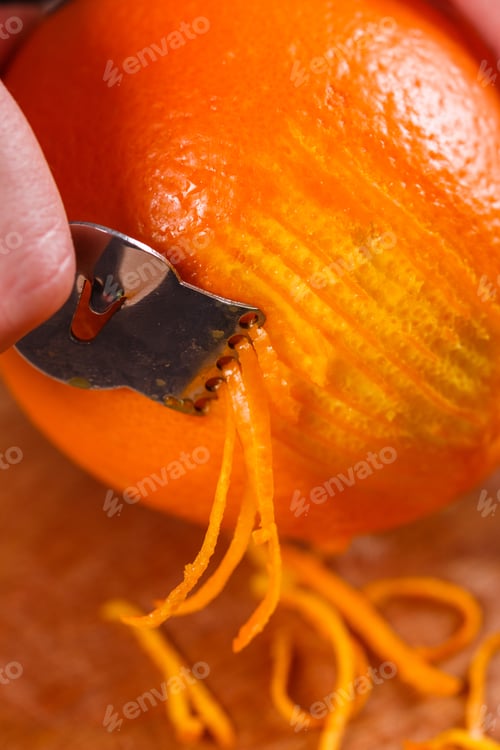 Preview: Young Woman In A Gray Aprons, Cuts An Orange Zest