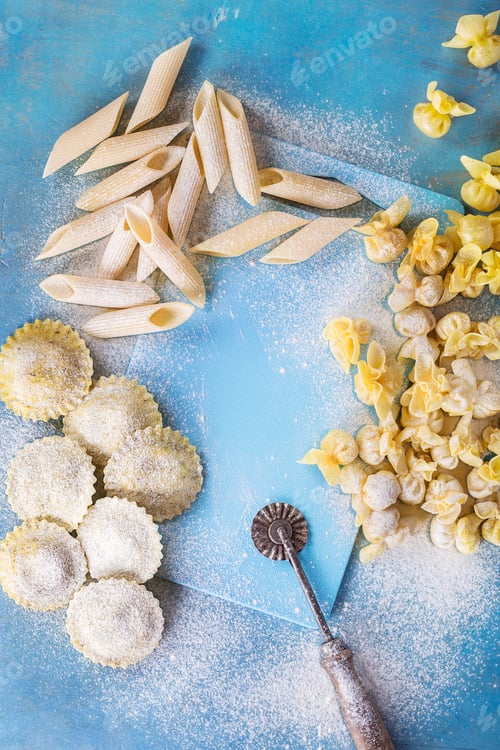 Preview: Homemade Italian Ravioli And Tortellini Pasta With Flour Over Blue Wooden Rustic Background