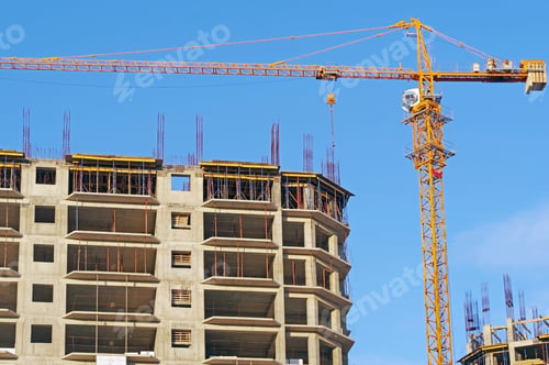 Preview: Building Crane And Building Under Construction Against Evening Blue Sky