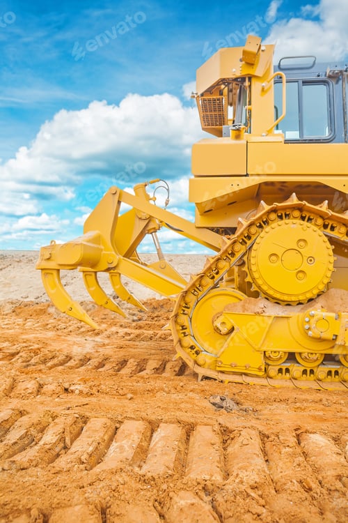 Preview: Part Of Bulldozer Standing On Sand At Construction Site Rear View With Background Sky