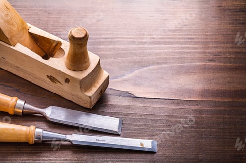 Preview: Vintage Woodworkers Plane And Two Chisels On Old Wooden Board With Copyspace Construction Concept