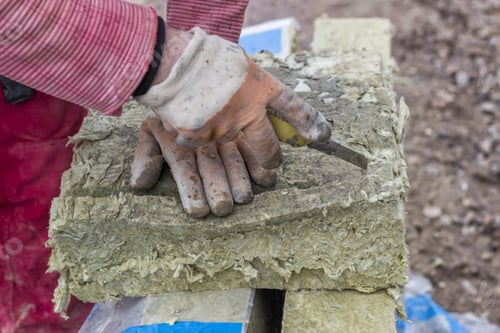 Preview: Cutting Mineral Wool Panel With A Craft Knive At Construction Site. Selective Focus.