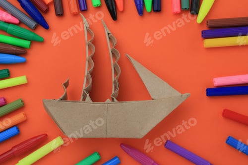 Preview: Origami Paper Sailboat Mockup. Selective Focus. A Lot Of Multi-Colored Felt-Tip Pens On A Blurry