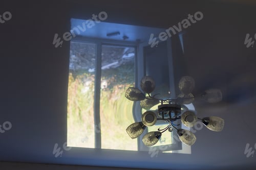 Preview: Off Chandelier On A Stretch White Ceiling With The Reflection Of A Light Window In The Darkness Of
