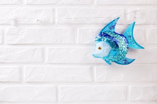 Preview: Nautical Decoration Near By White Brick Wall. Bright Blue Decorative Fish. Selective Focus. Place