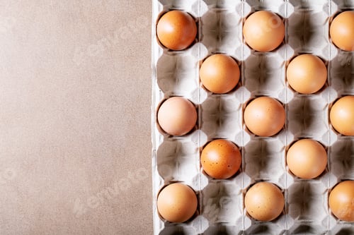 Preview: Eggs In Carton Box Over Brown Texture Background. Top View, Flat Lay