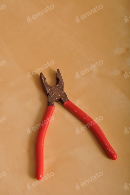 Preview: Red Pliers Tool On A Brown Wooden Background