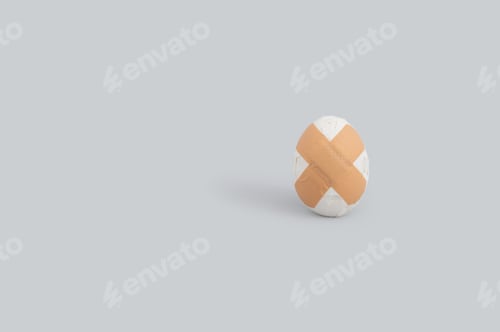Preview: Creative Funny Easter Concept With Broken Egg And Adhesive Bandage On Grey Background