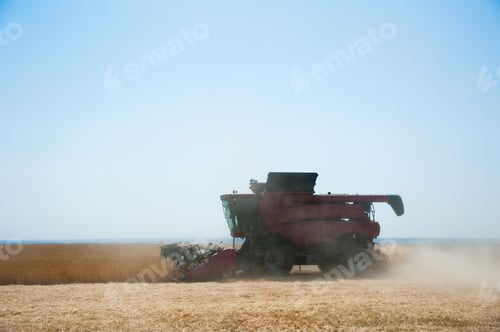 Preview: Agriculture. Combine Harvester On A Wheat Field With Blue Sky