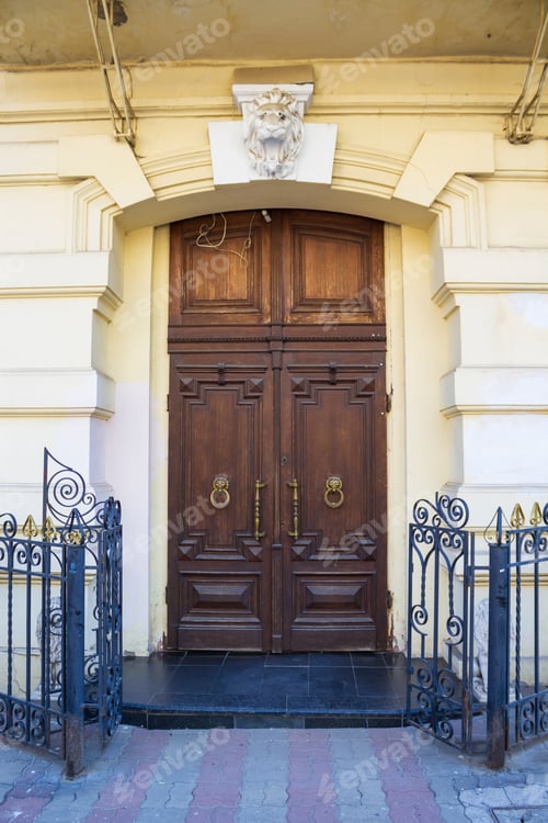 Preview: Carved Wooden Double Closed Door Illuminated By Sunspots On A City Street
