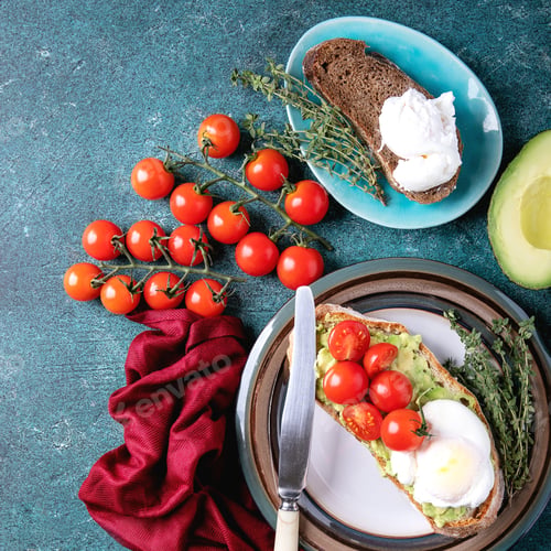 Preview: Smashed Avocado Toast With Poached Egg Served With Herbs And Tomatoes And Guacamole Over A Green