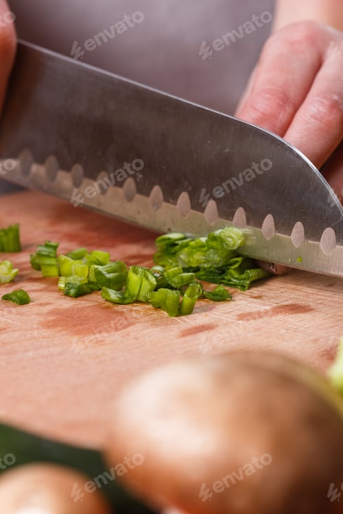 Preview: Young Woman Slicing Herbs In A Gray Apron