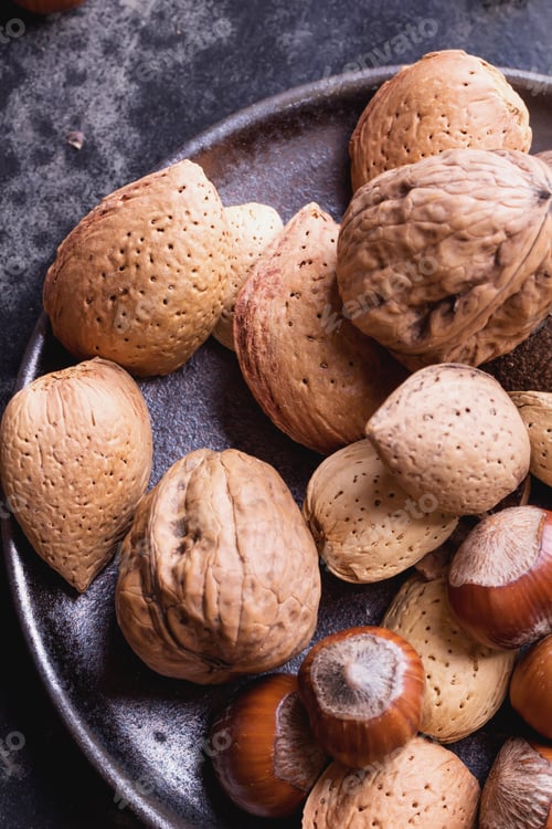 Preview: Selection Of Various Nuts In The Vintage Ceramic Plate, Black Background, Top View