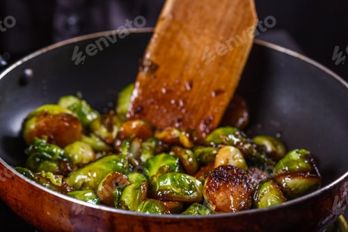 Preview: Young Woman Fries Brussels Sprouts On A Frying Pan