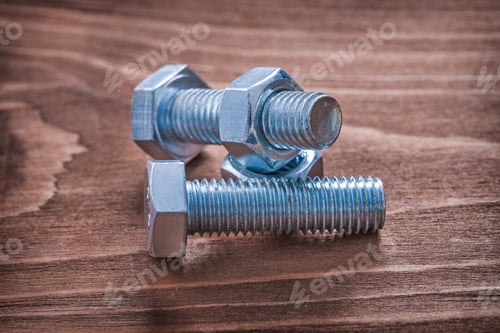 Preview: Metal Bolts And Nuts On Vintage Wooden Board Construction Concept