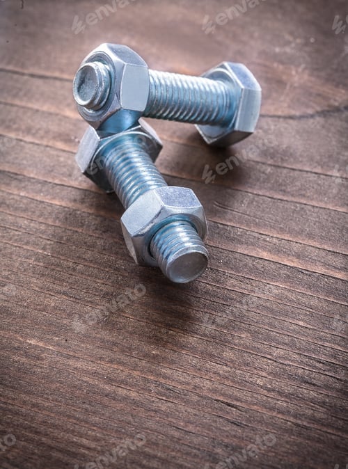 Preview: Some Steel Stainless Threaded Bolts And Screw Nuts On Vintage Wooden Board Construction Concept
