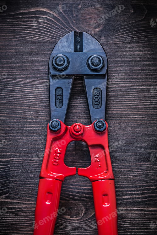 Preview: Metal Bolt Cutter On Wooden Board Construction Concept.
