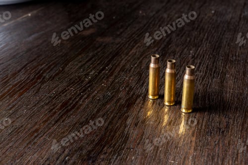 Preview: Empty Bullet Casings On A Dark, Wooden Table.