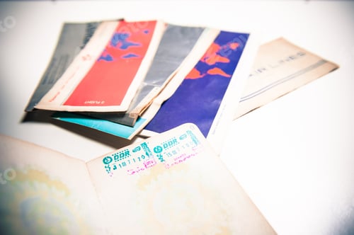 Preview: Old Passport With East Germany Stamp And Airlines Tickets Out Of Focus In Background