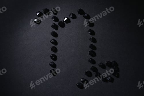 Preview: Symbol Of The Zodiac Sign Capricorn Made By Black Stones On A Black Background. Low Dark Key