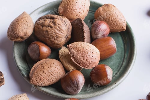Preview: Selection Of Various Nuts In The Vintage Ceramic Plate, Black Background, Top View