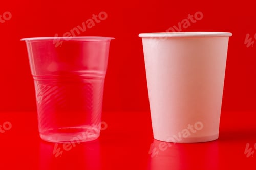 Preview: Plastic Transparent Disposable Cup For Drinking Water And An Ecologically Clean Paper Cup, On A Red