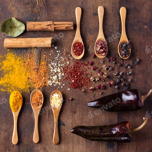 Preview: Various Asian Spices In Spoons Decorated With Whole Dry Chili And Lime Leaves.