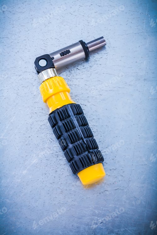 Preview: Metal Reversive Screwdriver With Rubber Handle On Metallic Background Construction Concept.