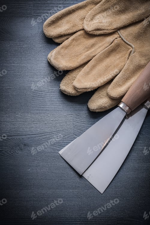 Preview: Safety Gloves And Paint Scrapers On Wood Board.