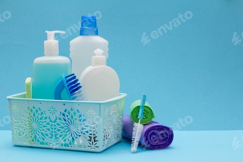Preview: Plastic Bottles Of Dishwashing Liquid, Glass And Tile Cleaner In Basket, Sponges, Garbage Bags And