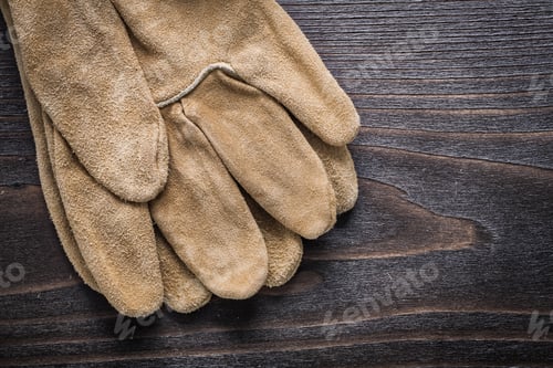 Preview: Pair Of Leather Working Gloves On Vintage Wooden Board Construction Concept.