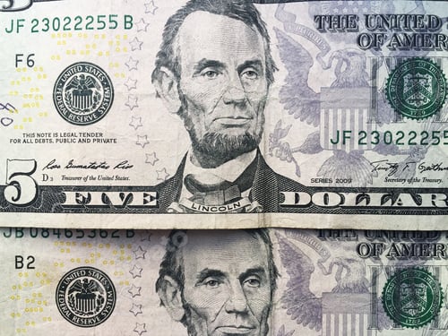 Billete de cinco dólares aislado sobre fondo verde