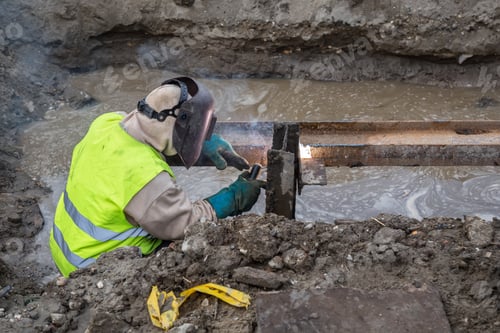 Preview: Welding Steel Beams In Trench Filled With Water At Construction Site.