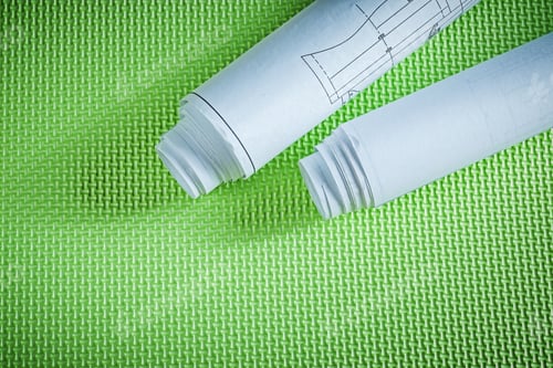 Preview: Rolled Engineering Drawings On Green Surface Construction Concept.
